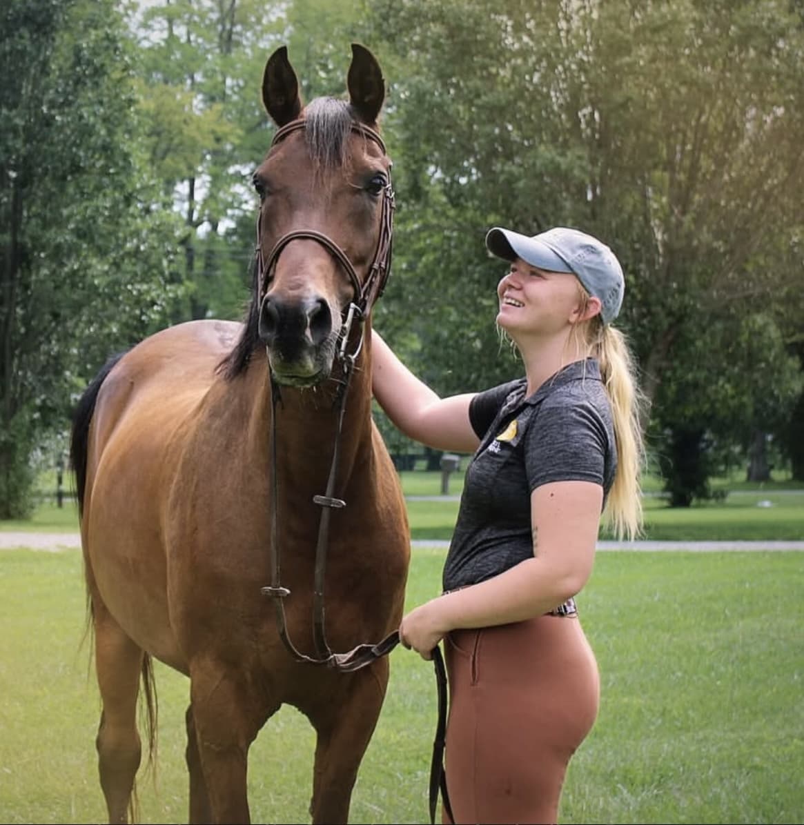Mackenzie standing alongside Dax, her bay sport horse